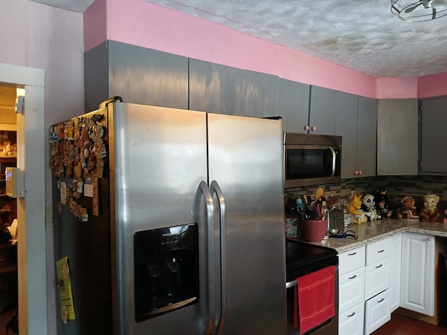 kitchen with appliances with stainless steel finishes, decorative backsplash, and light stone counters