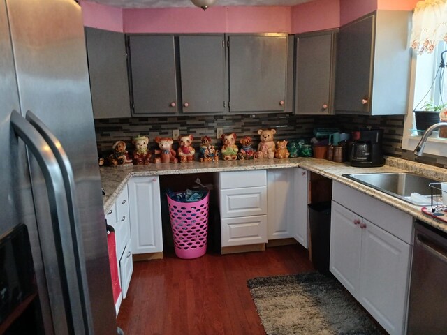 kitchen featuring a sink, backsplash, stainless steel fridge with ice dispenser, dishwasher, and dark wood finished floors