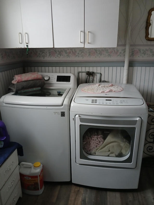 laundry room featuring washer and dryer, wainscoting, cabinet space, and wallpapered walls