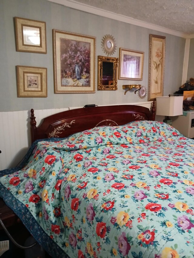 bedroom featuring ornamental molding and a textured ceiling