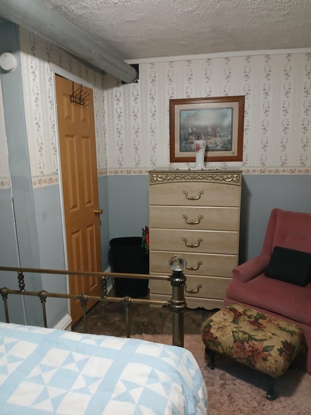 bedroom with a textured ceiling and wallpapered walls