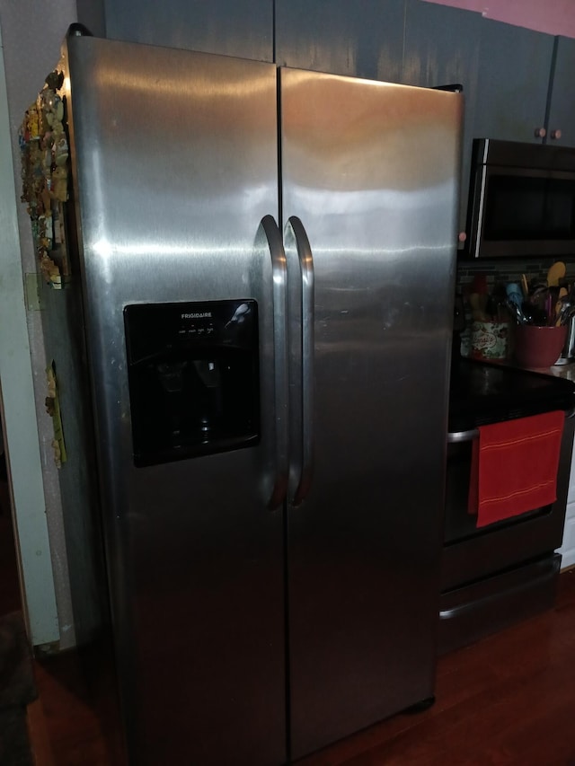 details featuring electric range, stainless steel refrigerator with ice dispenser, and wood finished floors