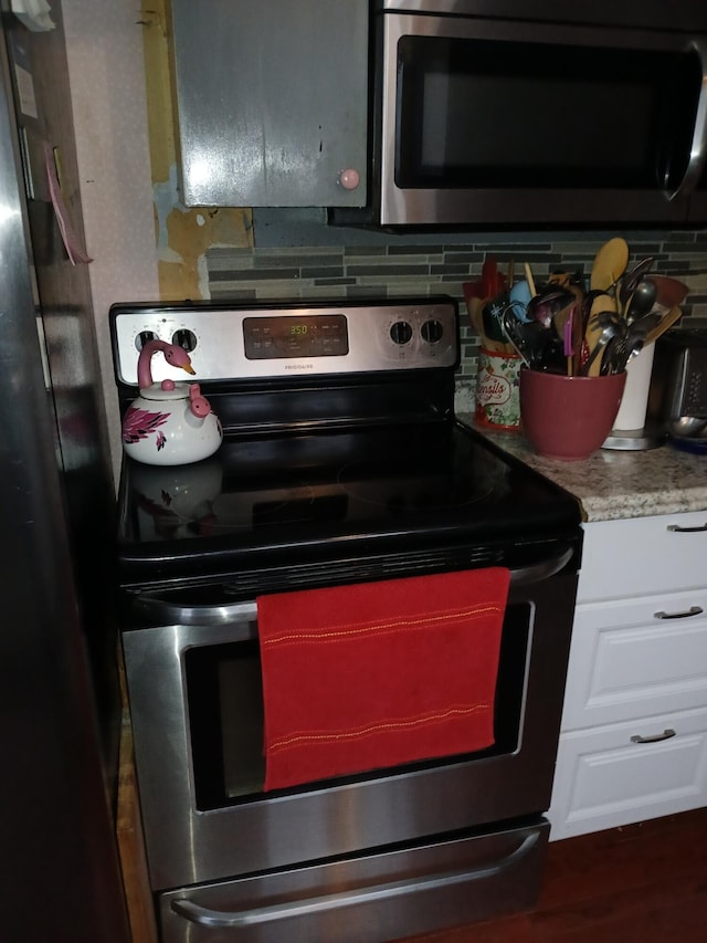 kitchen featuring light countertops, appliances with stainless steel finishes, white cabinets, and decorative backsplash