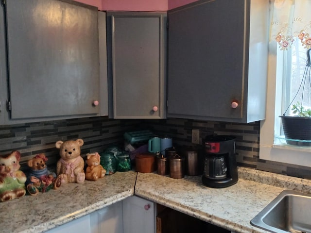 kitchen featuring light countertops, decorative backsplash, and gray cabinetry