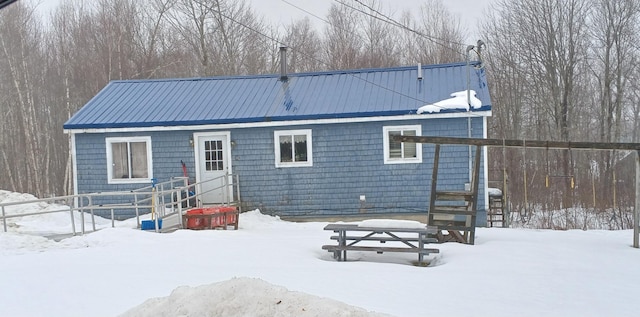 snow covered back of property with metal roof