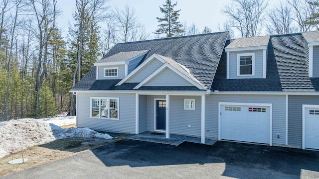 view of front of home featuring driveway, a shingled roof, and a garage