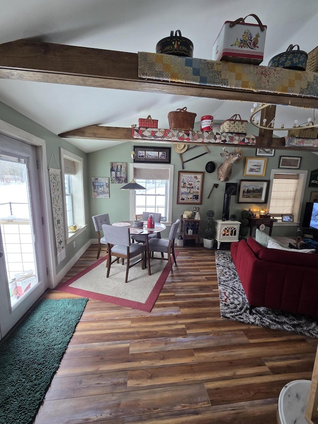 dining area with lofted ceiling with beams, baseboards, and wood finished floors