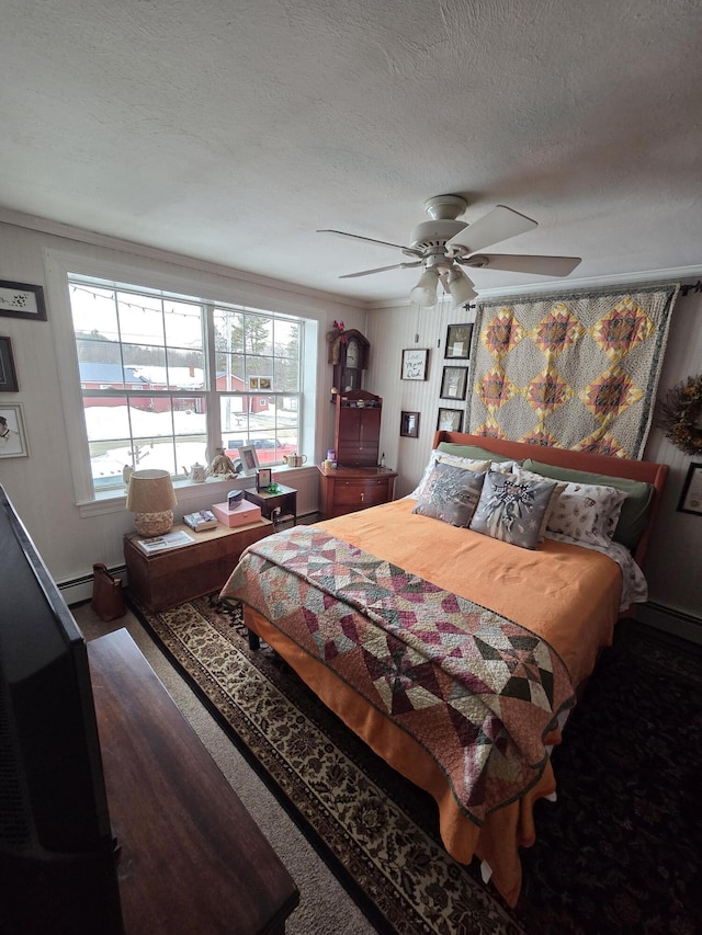 bedroom with a baseboard radiator, ceiling fan, and a textured ceiling