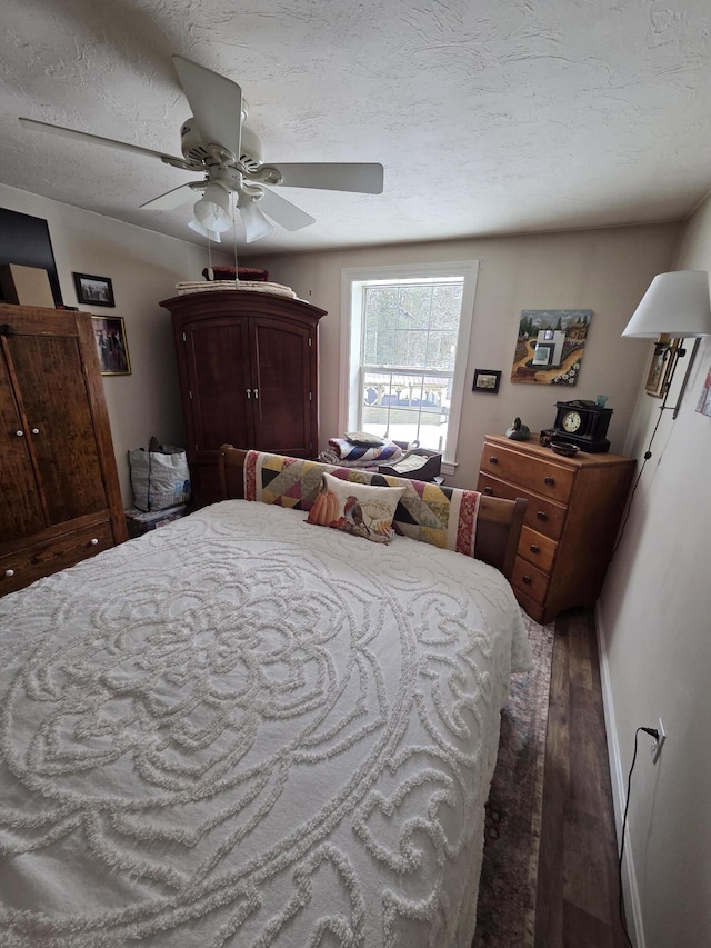 bedroom featuring a textured ceiling, ceiling fan, and wood finished floors