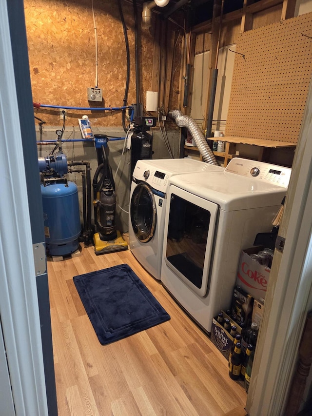 washroom featuring laundry area, washer and clothes dryer, and wood finished floors