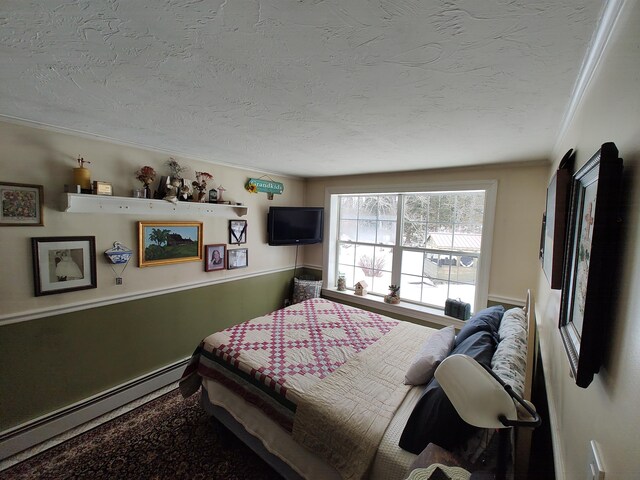 bedroom featuring crown molding, a baseboard heating unit, and a textured ceiling