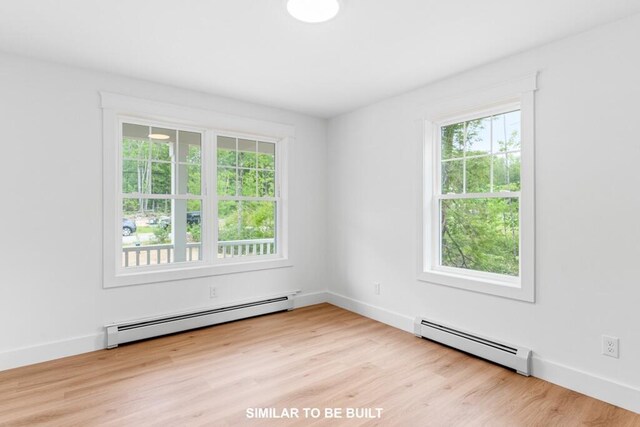 LOT11 Raspberry Ln, Topsham, ME 04086 - empty room with a healthy amount of sunlight, wood finished floors, and a baseboard heating unit