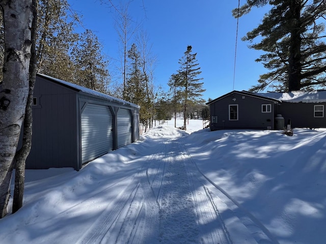 yard covered in snow with an outbuilding