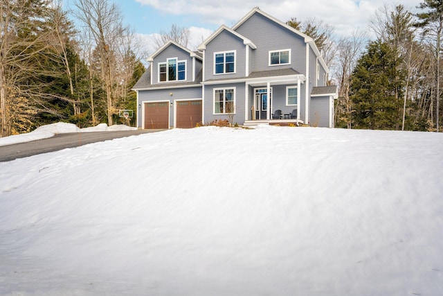 view of front of home featuring a porch, an attached garage, and driveway