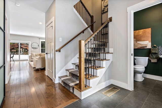 staircase featuring visible vents, recessed lighting, baseboards, and wood finished floors