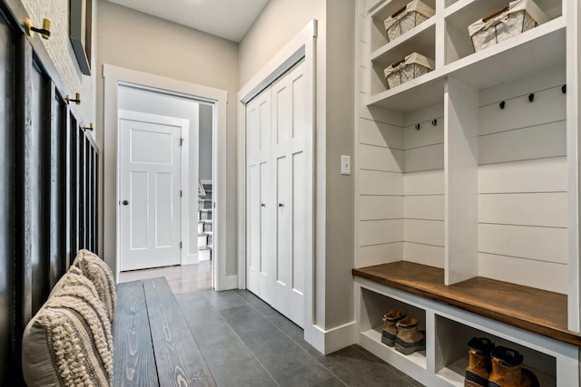 mudroom with dark tile patterned floors