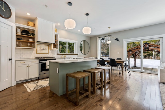 kitchen featuring open shelves, stainless steel electric stove, dark wood-style floors, light countertops, and decorative backsplash