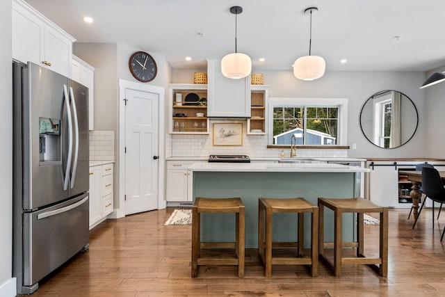 kitchen with open shelves, a sink, light countertops, stainless steel refrigerator with ice dispenser, and white cabinetry