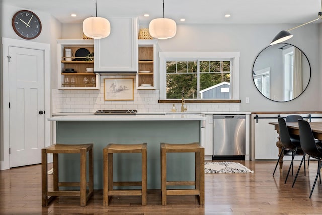 kitchen with wood finished floors, open shelves, decorative backsplash, dishwasher, and a center island