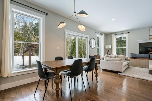 dining area with recessed lighting, baseboards, a glass covered fireplace, and hardwood / wood-style flooring