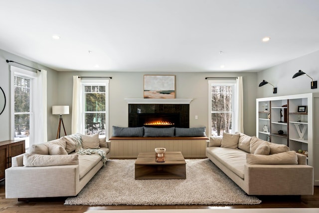 living room with recessed lighting, a healthy amount of sunlight, wood finished floors, and a tiled fireplace