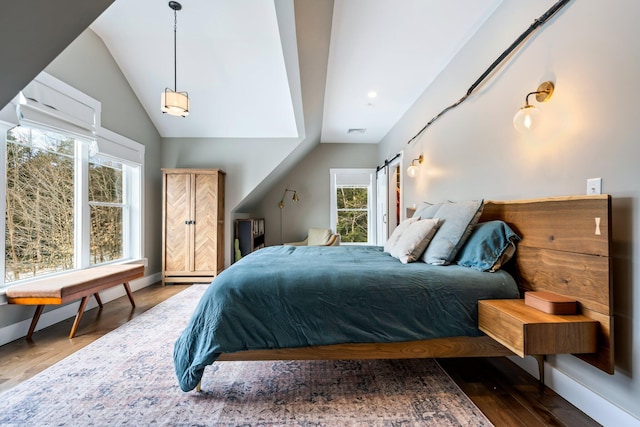 bedroom with baseboards, a baseboard heating unit, lofted ceiling, and wood finished floors