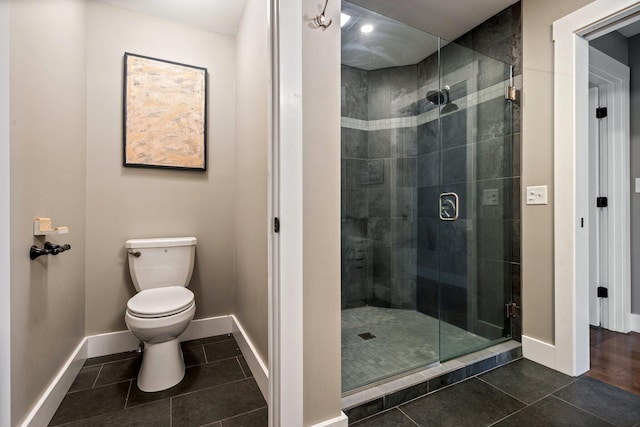 full bath with tile patterned floors, a stall shower, toilet, and baseboards