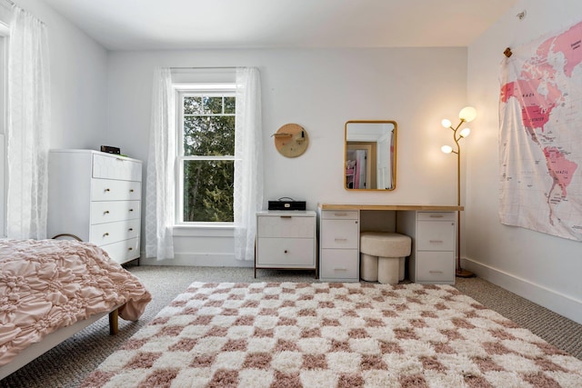 bedroom featuring multiple windows, light colored carpet, and baseboards