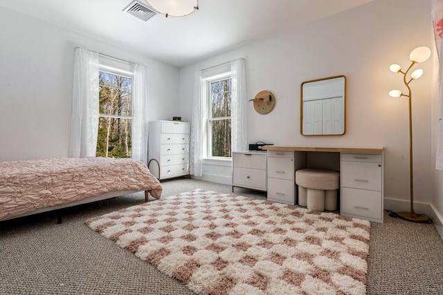 bedroom featuring multiple windows, baseboards, visible vents, and light carpet