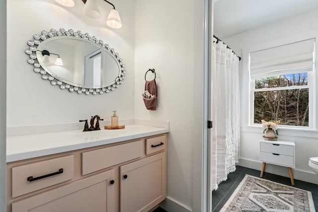 bathroom with tile patterned floors, baseboards, toilet, and vanity