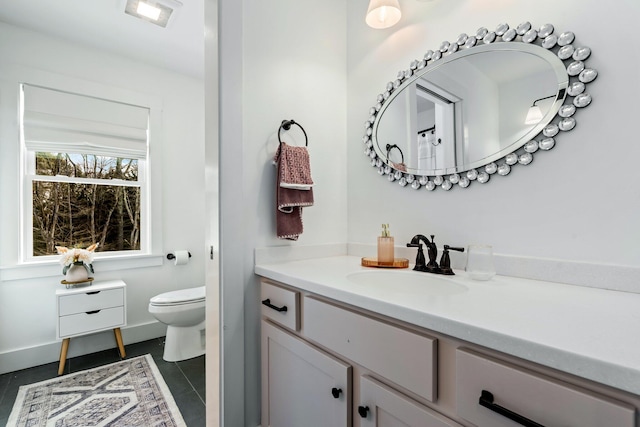 bathroom featuring tile patterned flooring, toilet, vanity, and baseboards