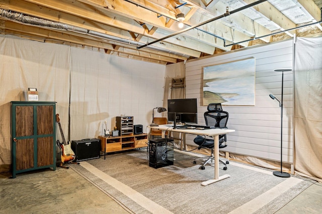 office area with wooden walls and concrete floors