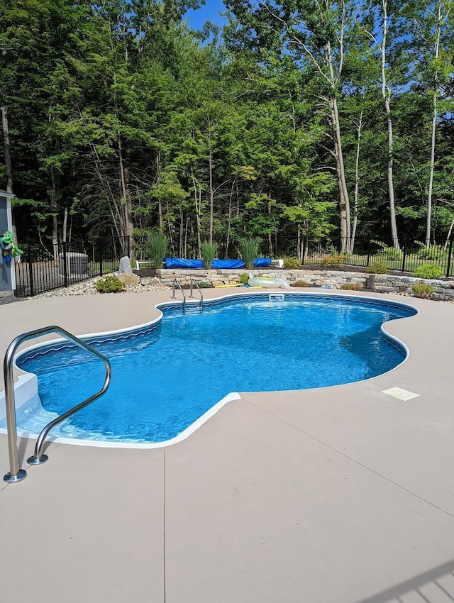 view of swimming pool with a patio area, a fenced in pool, and fence