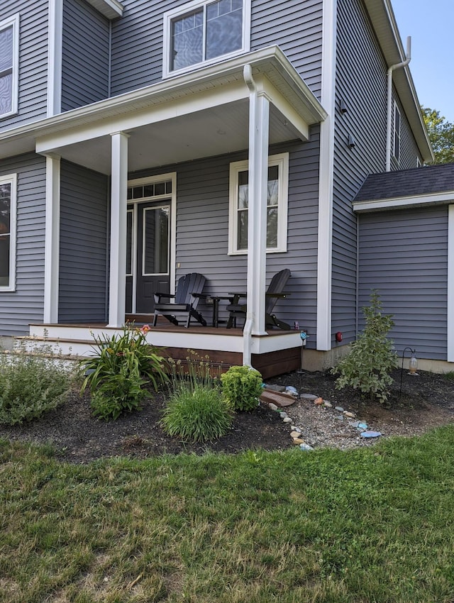 property entrance featuring a yard and a porch