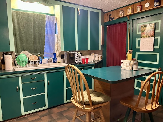 kitchen with a breakfast bar, green cabinets, and a textured ceiling