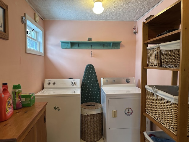 clothes washing area with laundry area, a textured ceiling, and washer and dryer