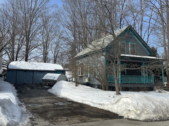 snow covered property featuring covered porch