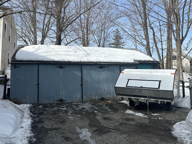 snow covered structure with an outbuilding