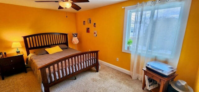 carpeted bedroom with ceiling fan and baseboards