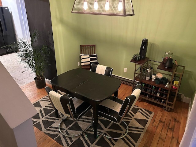 dining space with baseboards and wood finished floors