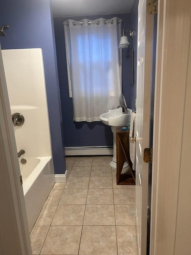 full bath featuring a baseboard radiator, tile patterned flooring, a sink, baseboards, and shower / washtub combination