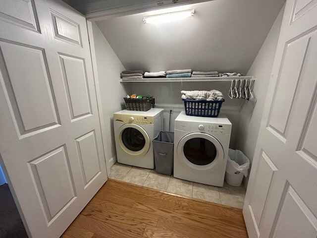 clothes washing area with light wood-style floors and washer and dryer