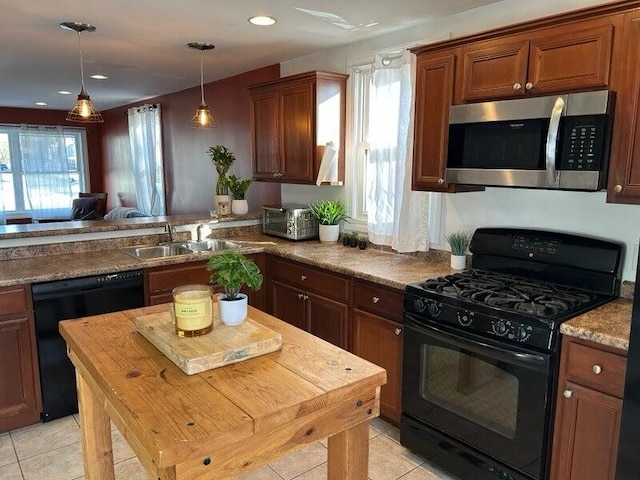 kitchen with black appliances, light tile patterned floors, a sink, and decorative light fixtures