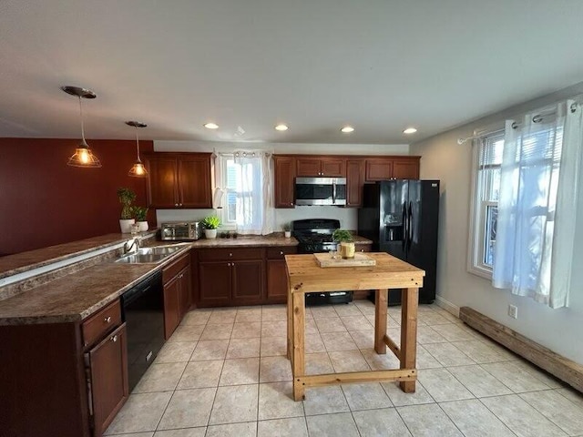 kitchen with light tile patterned floors, black appliances, dark countertops, and a sink