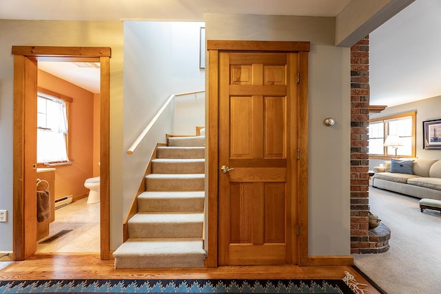 stairway with carpet floors, a baseboard radiator, wood finished floors, and visible vents