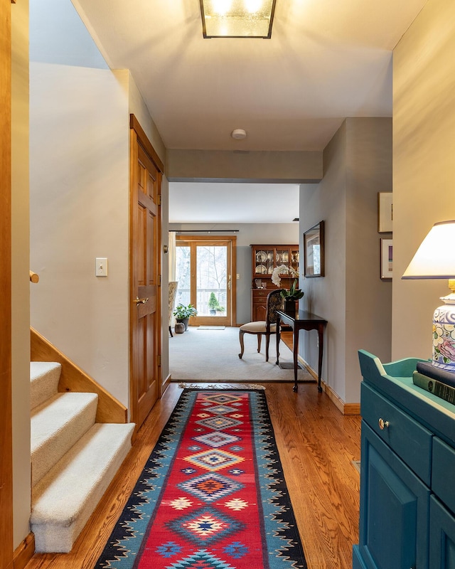 interior space with light wood-style floors, stairway, and baseboards