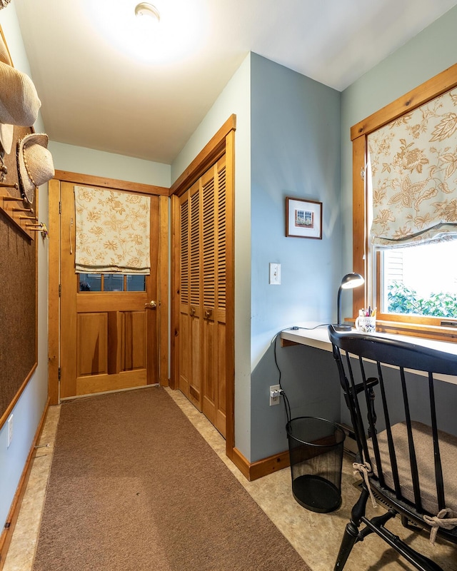 interior space featuring baseboards and light colored carpet