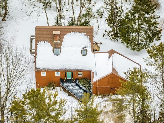 snow covered property with a chimney