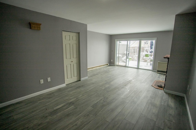 spare room with baseboards and wood finished floors