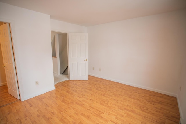 spare room featuring baseboards and light wood-style flooring